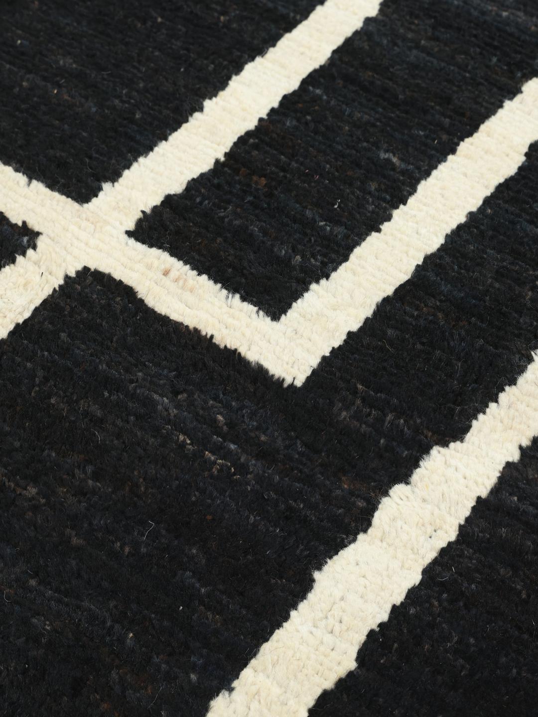Handgeknoopt Afghaans Gabbeh Modern tapijt met een zwart veld en witte geometrische rechthoekige contouren.