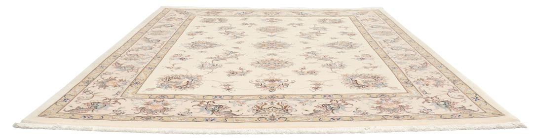 Een rechthoekig Tabriz tapijt uit het Midden-Oosten met beige tinten en bloemmotieven