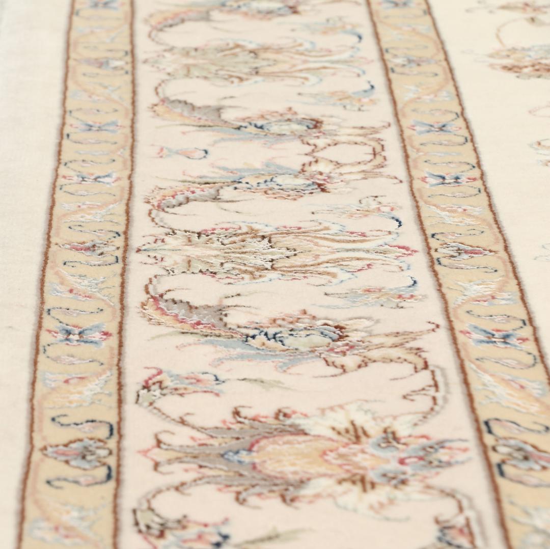 Een rechthoekig Tabriz tapijt uit het Midden-Oosten met beige tinten en bloemmotieven