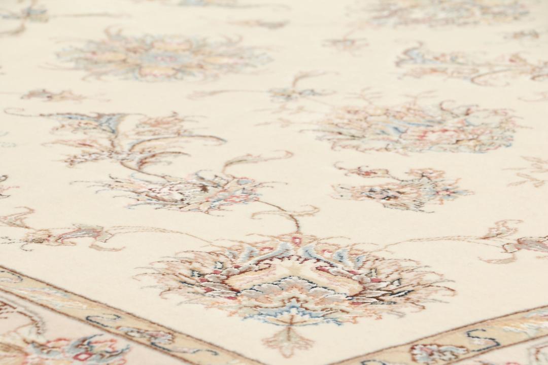 Een rechthoekig Tabriz tapijt uit het Midden-Oosten met beige tinten en bloemmotieven