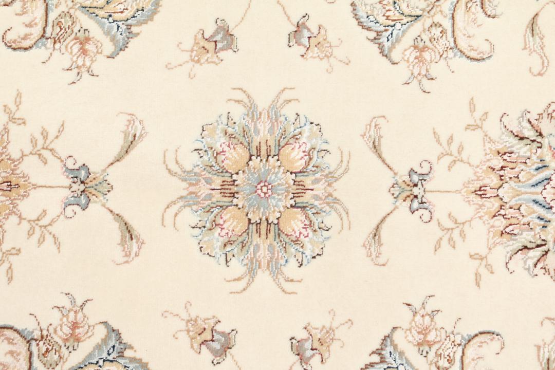 Een rechthoekig Tabriz tapijt uit het Midden-Oosten met beige tinten en bloemmotieven