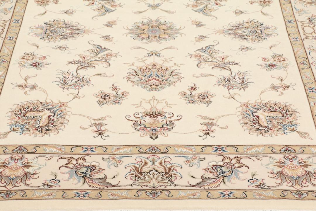 Een rechthoekig Tabriz tapijt uit het Midden-Oosten met beige tinten en bloemmotieven