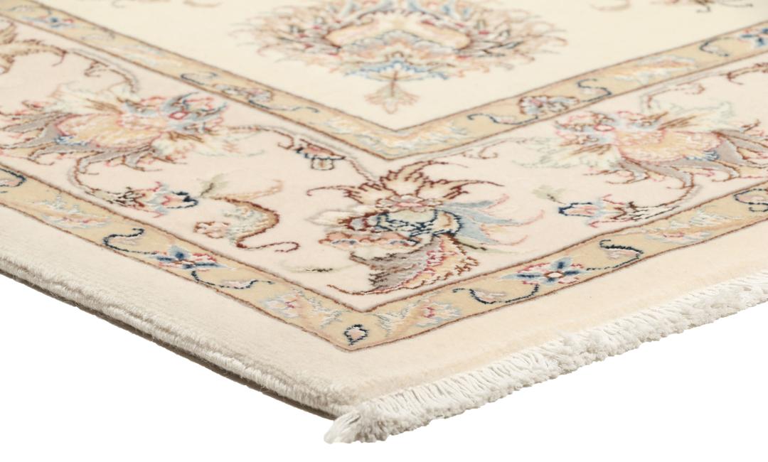 Een rechthoekig Tabriz tapijt uit het Midden-Oosten met beige tinten en bloemmotieven