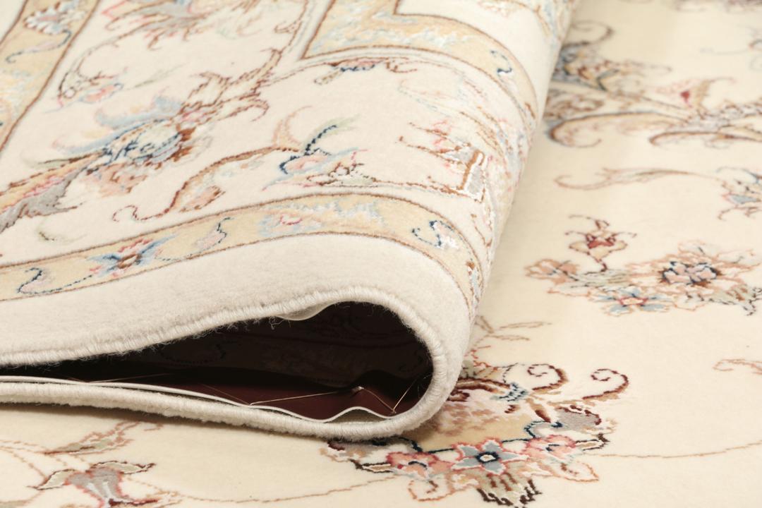 Een rechthoekig Tabriz tapijt uit het Midden-Oosten met beige tinten en bloemmotieven