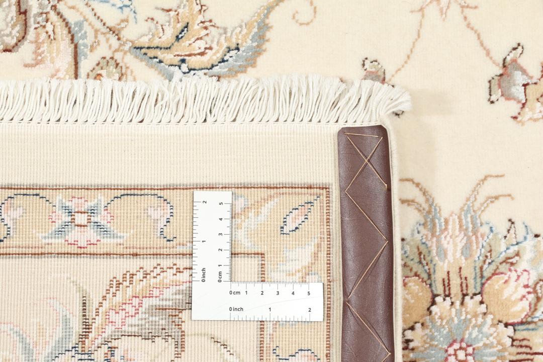 Een rechthoekig Tabriz tapijt uit het Midden-Oosten met beige tinten en bloemmotieven