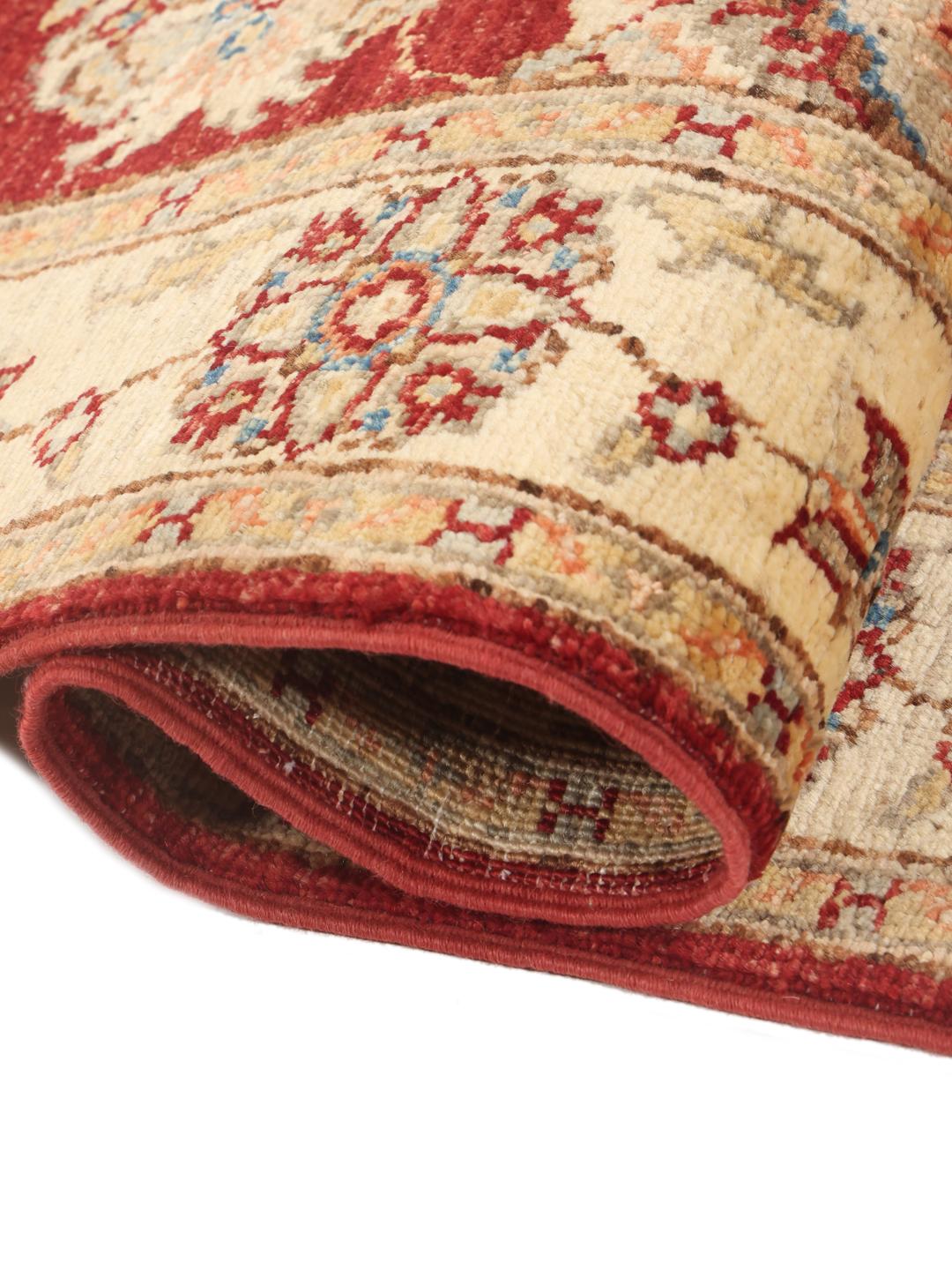 Hand-knotted Afghan rug with a red field and traditional floral patterns