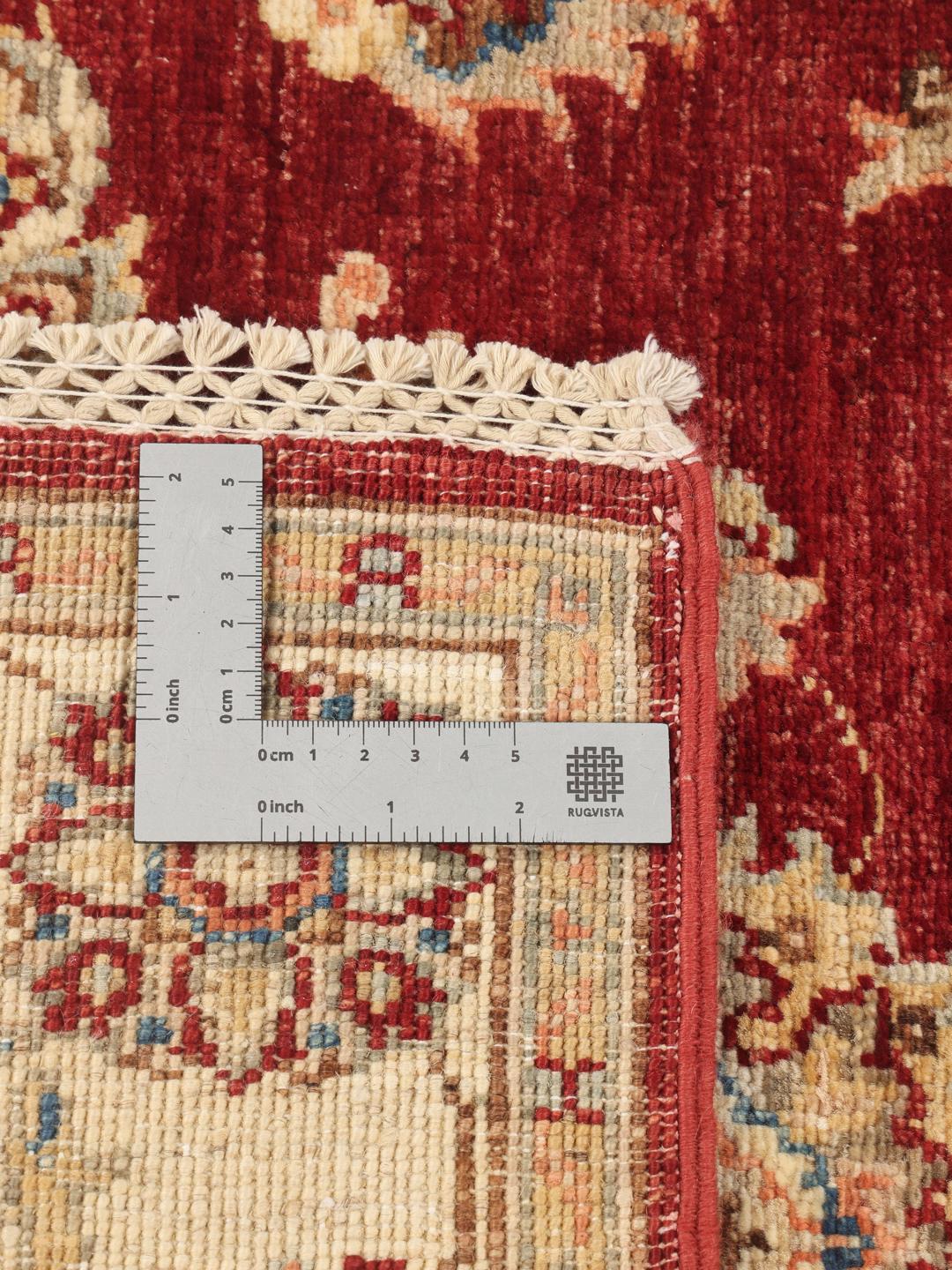 Hand-knotted Afghan rug with a red field and traditional floral patterns