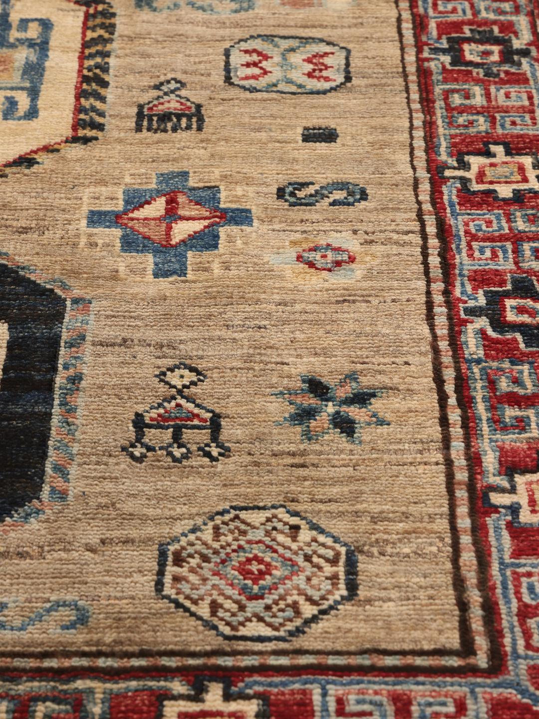 Hand-knotted Kazak rug from Afghanistan with a geometric pattern in beige, red, and blue