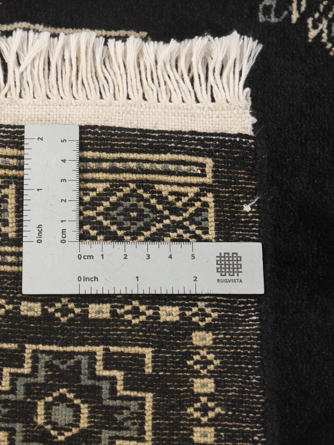 Hand-knotted Pakistan Bokhara rug in black with traditional geometric motifs