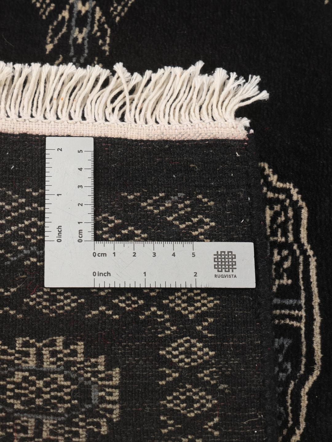 Hand-knotted Pakistan Bokhara rug in black with traditional geometric motifs