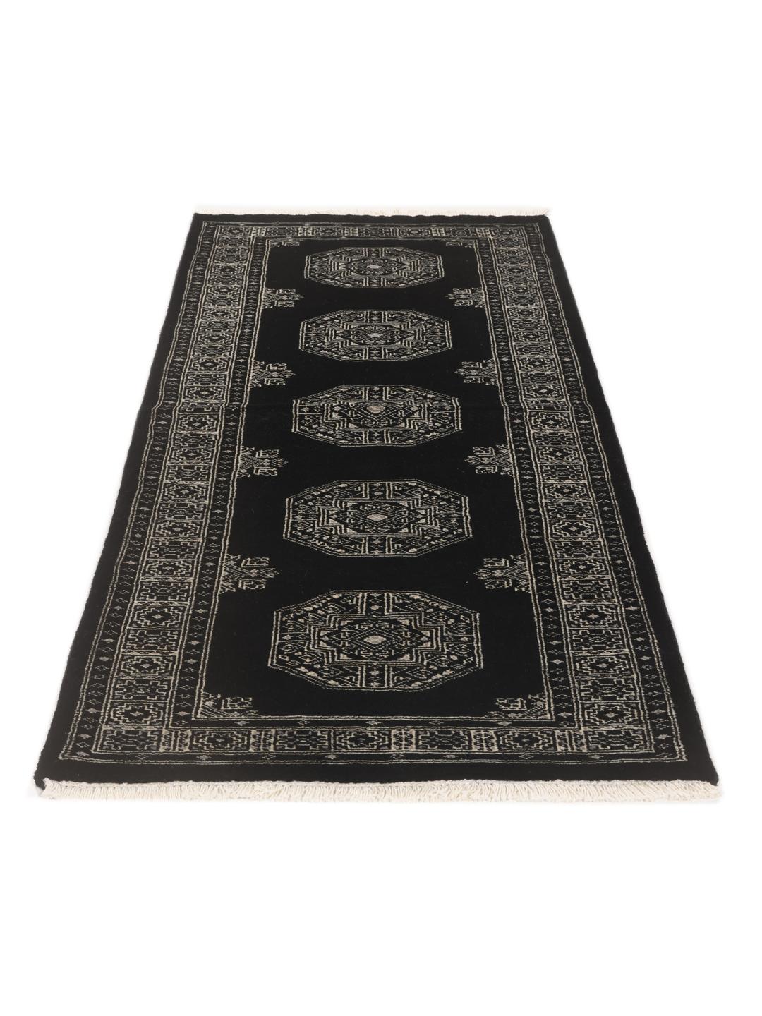Een handgeknoopte Pakistaanse loper met een zwart veld en geometrische medaillonpatronen.