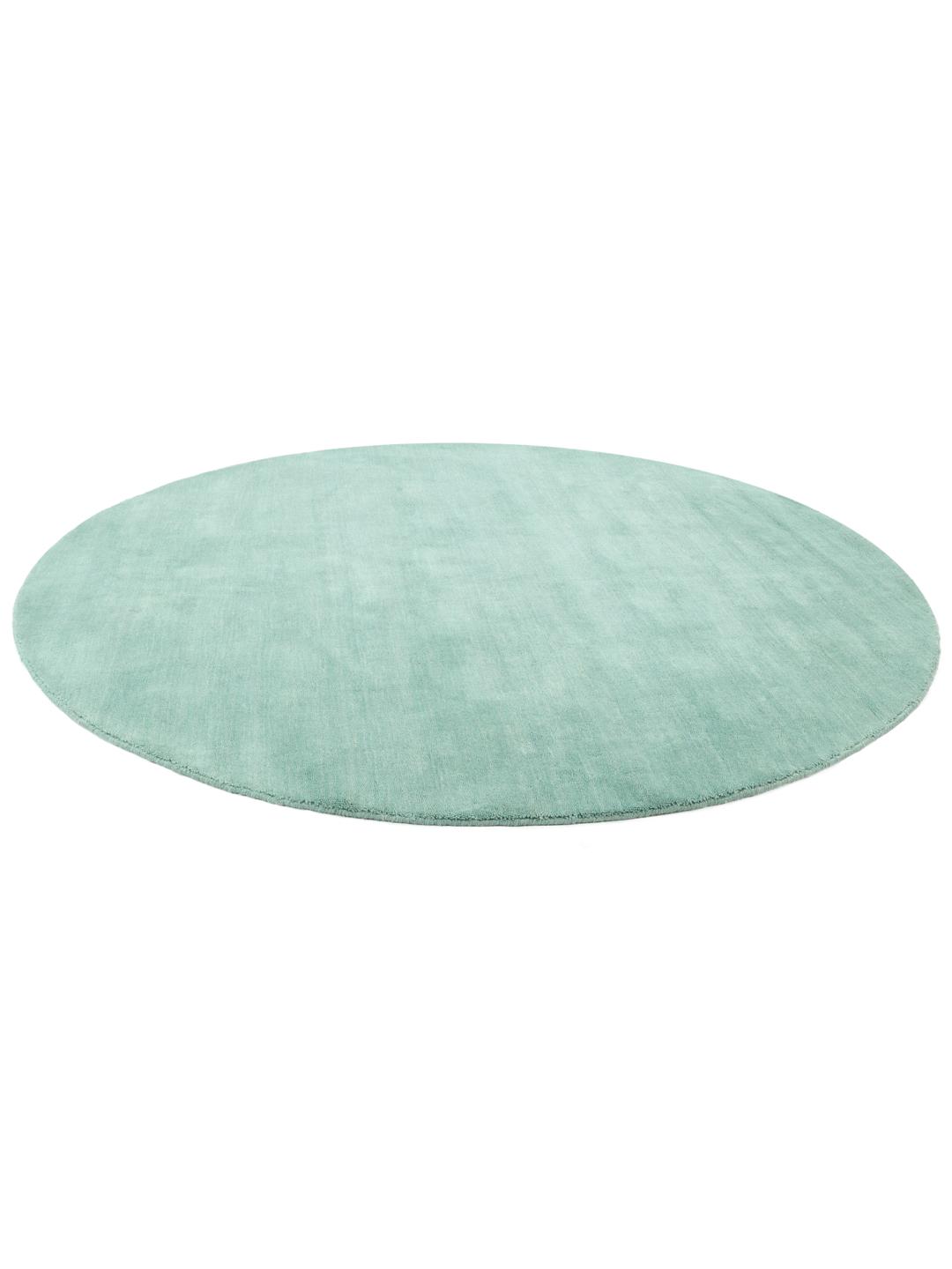 Round teal rug made from wool