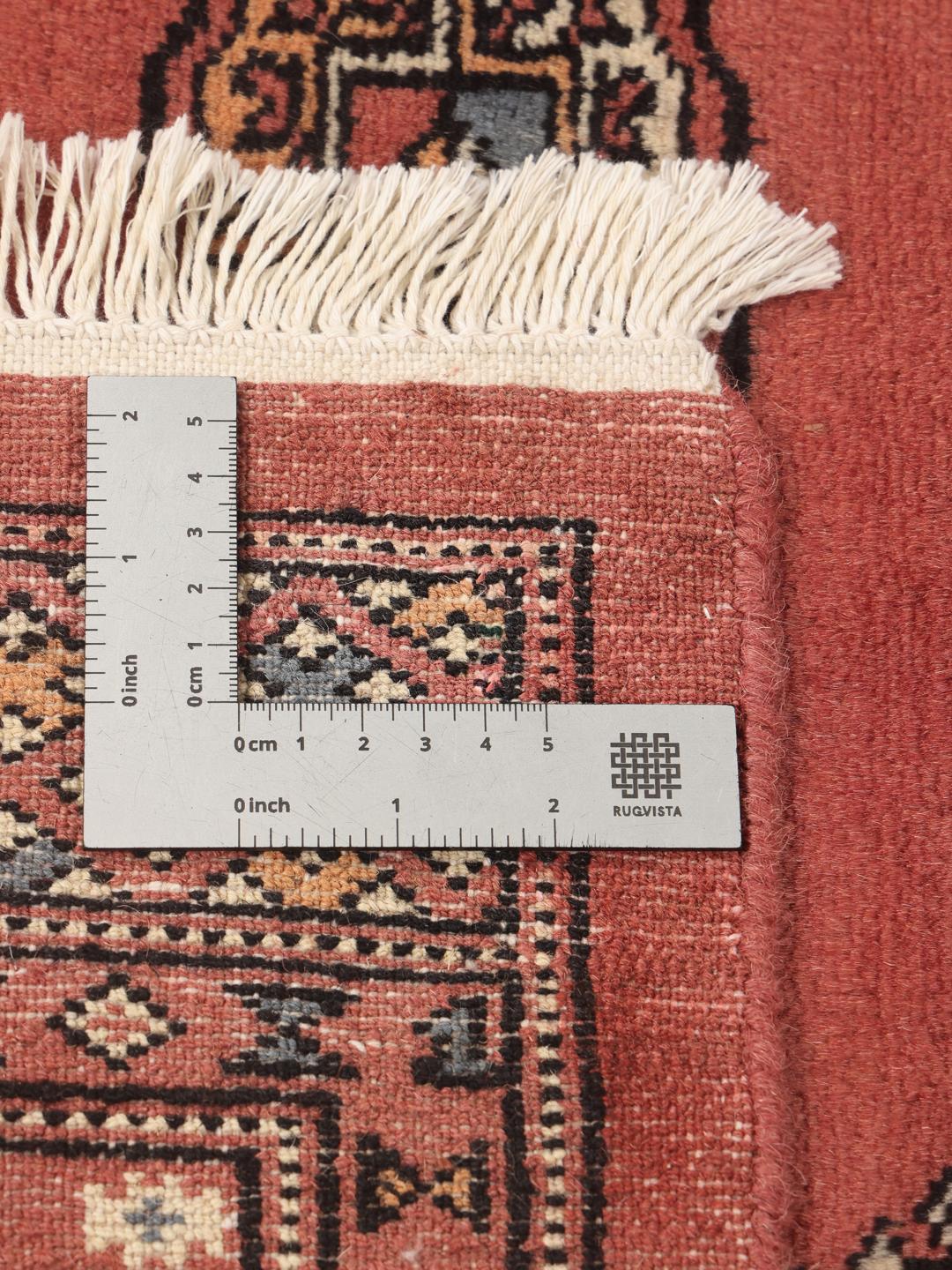 Een handgeknoopt Pakistan Bokhara 2ply vloerkleed met een rood veld en herhalende geometrische motieven.