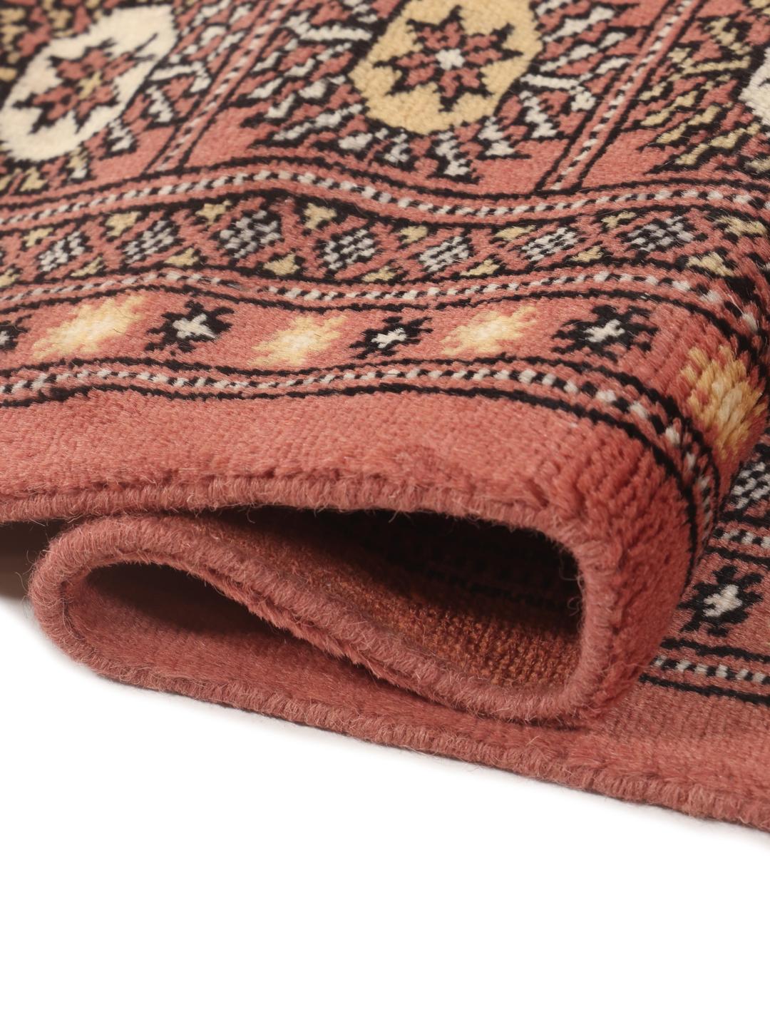 Een handgeknoopt Pakistan Bokhara 2ply vloerkleed met een rood veld en herhalende geometrische motieven.
