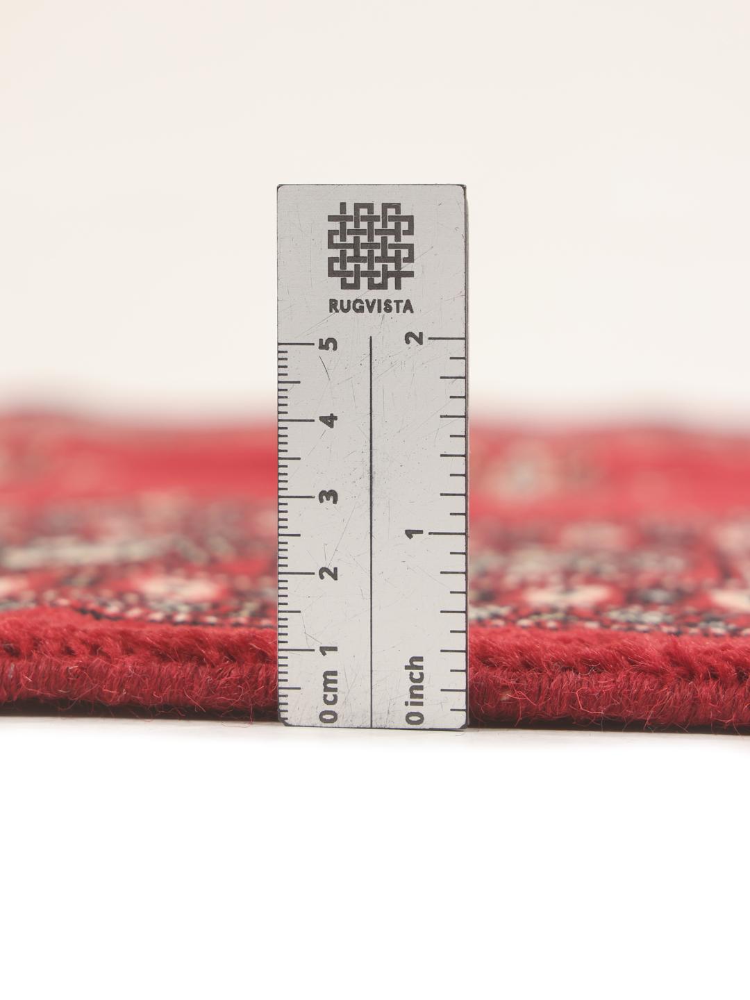 Hand-knotted Pakistan Bokhara rug in a deep red color with traditional motifs.