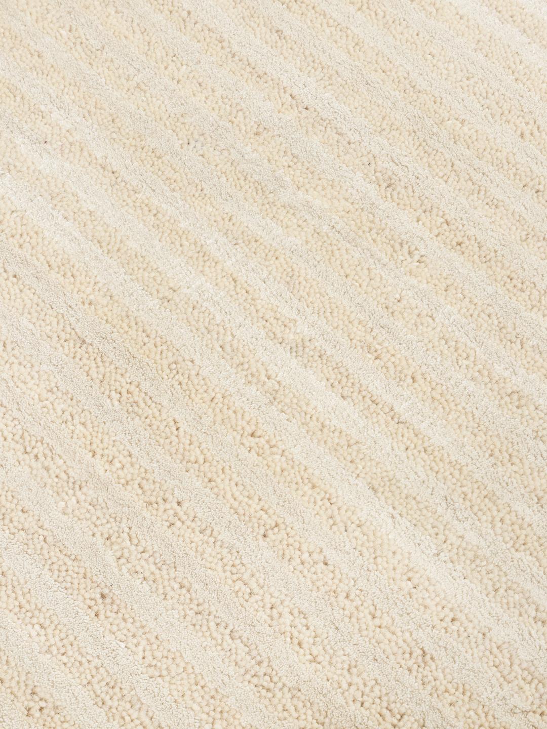 Un tapis rond beige avec un motif à fines rayures