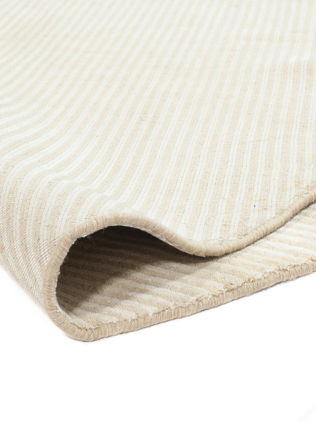 Un tapis rond beige avec un motif à fines rayures