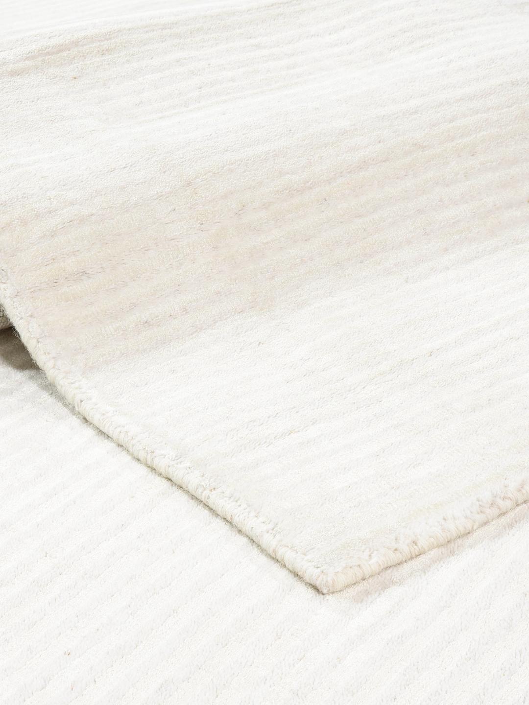 Un tapis en laine blanche avec une texture à fines rayures.