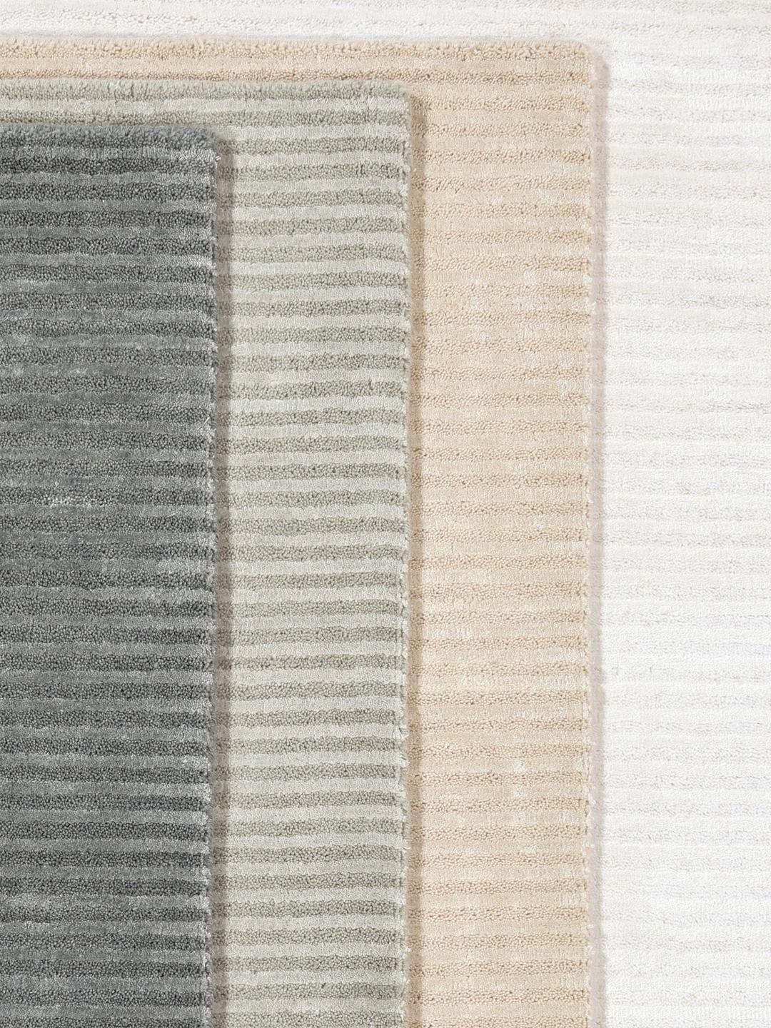 Un tapis en laine blanche avec une texture à fines rayures.