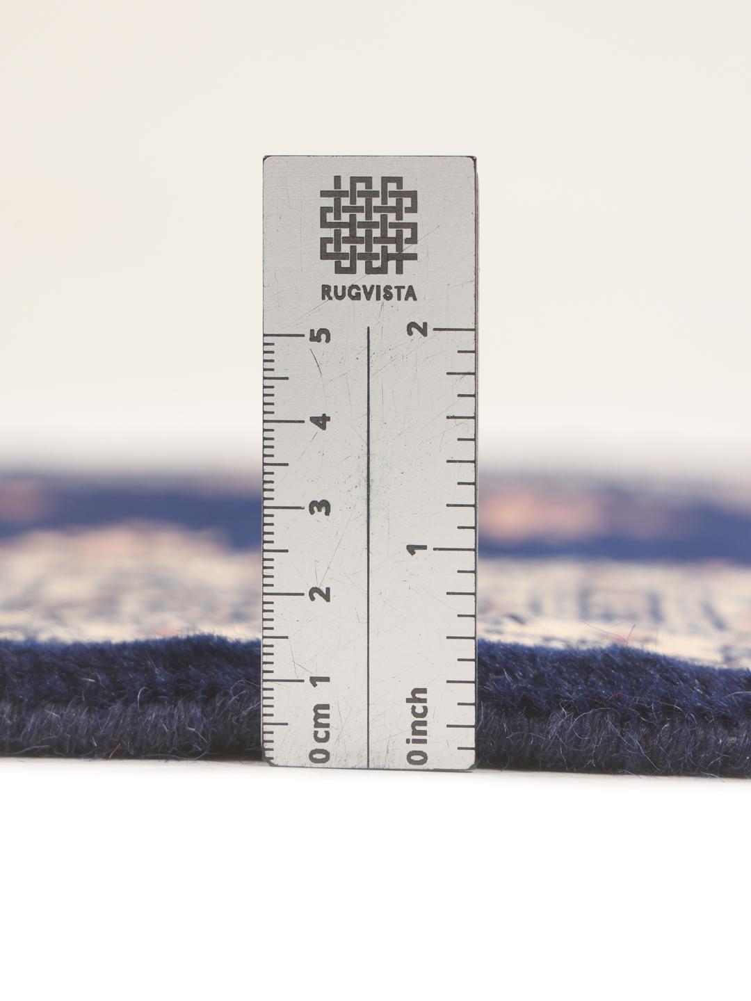 A long, narrow hand-knotted runner from Pakistan with a deep blue field and repeating motifs.