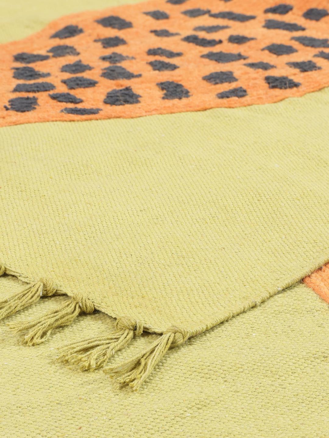 Handgeweven lichtgroen en oranje vloerkleed met een speels luipaardmotief en franjes