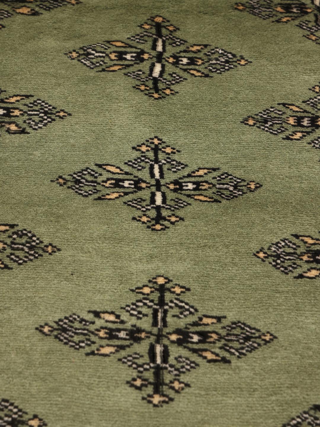 Een vierkant Pakistan Bokhara handgeknoopt wollen tapijt in groen met traditionele motieven.