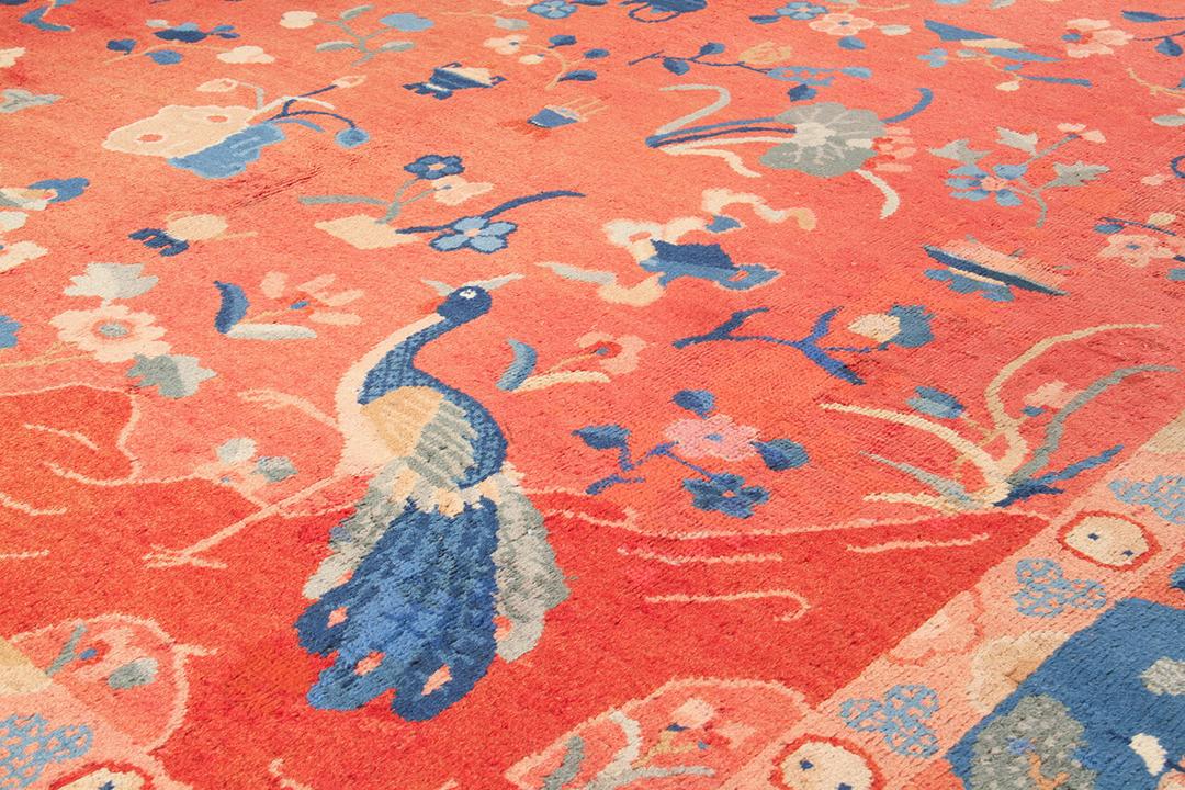 Antiek Chinees tapijt met een rood veld en picturale motieven