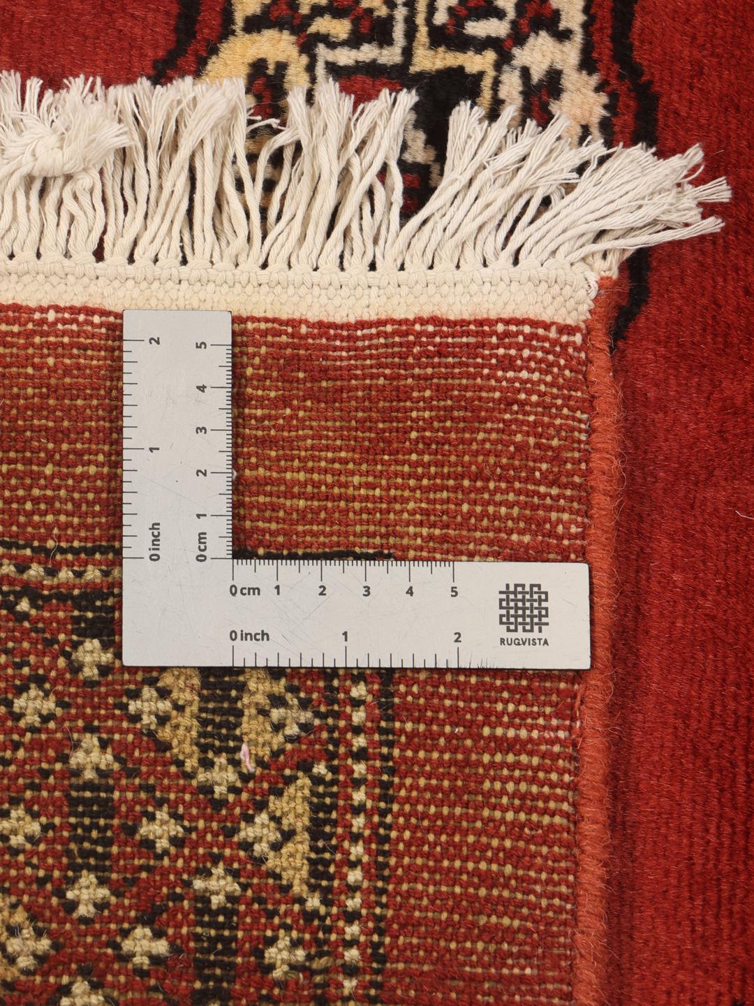Ein großer, rechteckiger, handgeknüpfter Pakistan Bokhara Teppich in Dunkelrot mit wiederkehrenden Motiven.