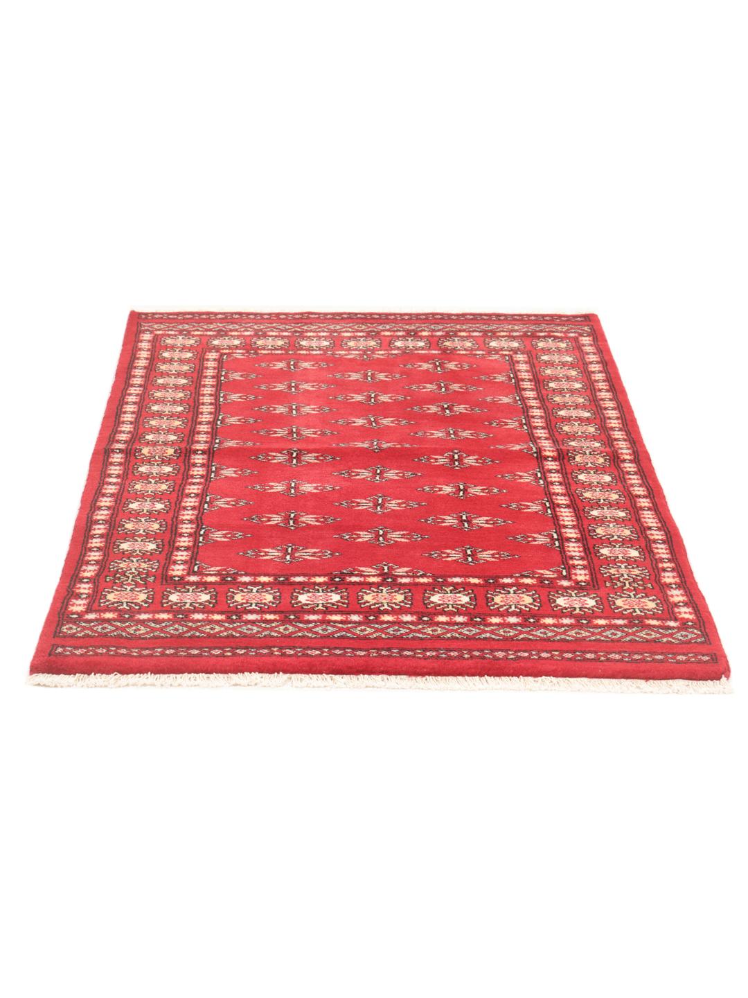 A hand-knotted Pakistan Bokhara rug with a deep red field and traditional geometric motifs.