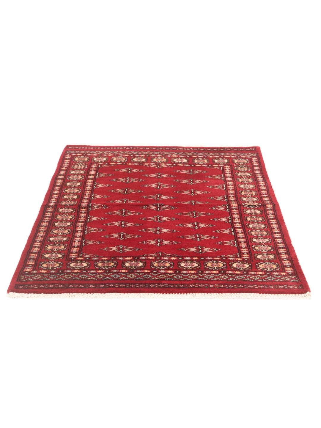 A hand-knotted Pakistan Bokhara rug with a deep red field and traditional geometric motifs.