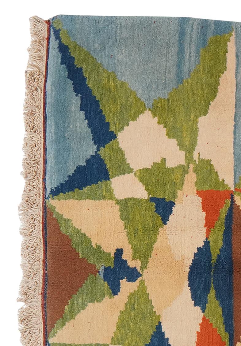 Een kleurrijk handgeknoopt Turks Berber-tapijt met geometrische patronen in blauw, groen en oranje.