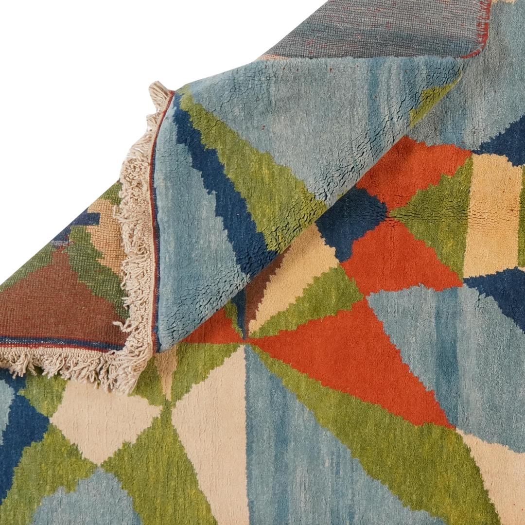 Een kleurrijk handgeknoopt Turks Berber-tapijt met geometrische patronen in blauw, groen en oranje.