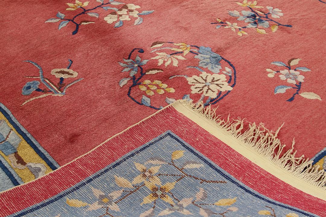Antiek Chinees tapijt met bloemmotieven op een rode achtergrond