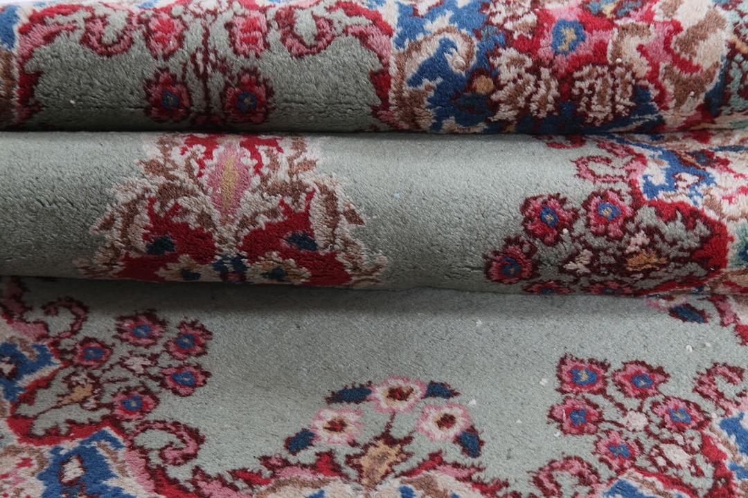 Antique Kerman rug from the Middle East in light-green with floral motifs