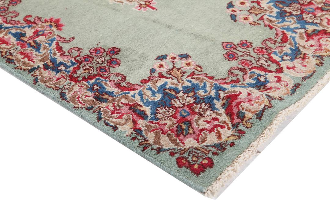 Antique Kerman rug from the Middle East in light-green with floral motifs