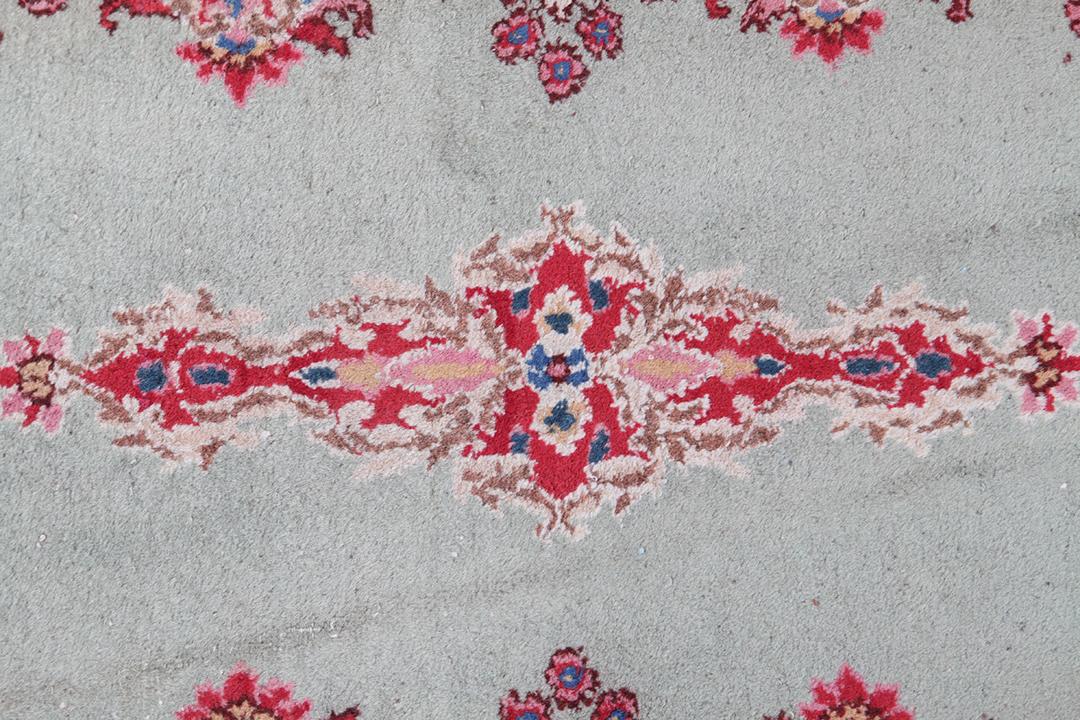 Antique Kerman rug from the Middle East in light-green with floral motifs