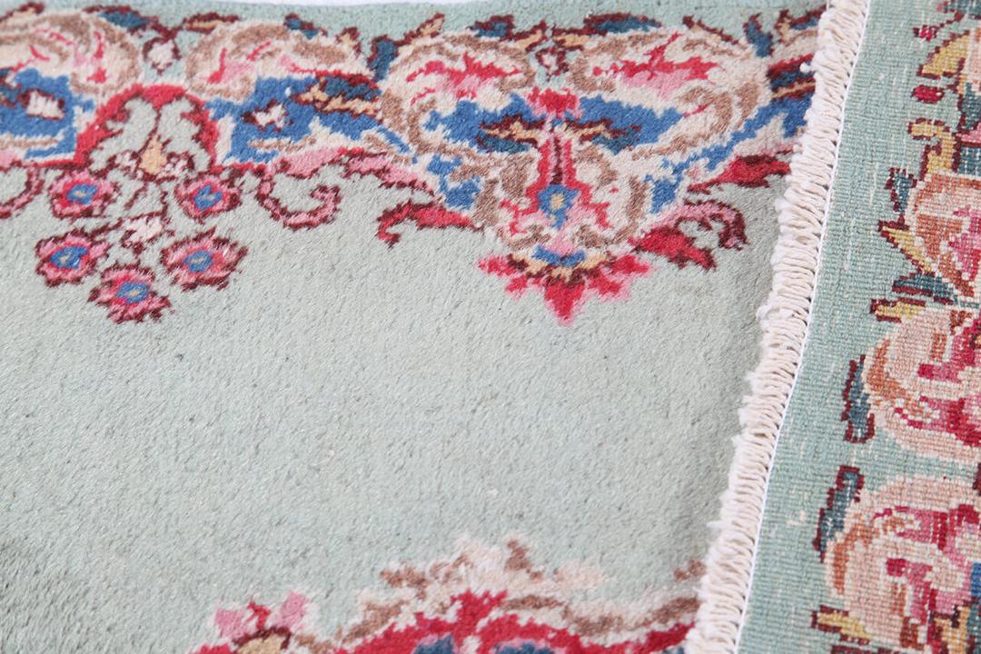 Antique Kerman rug from the Middle East in light-green with floral motifs