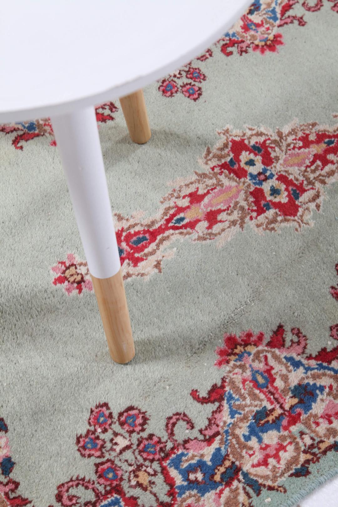 Antique Kerman rug from the Middle East in light-green with floral motifs