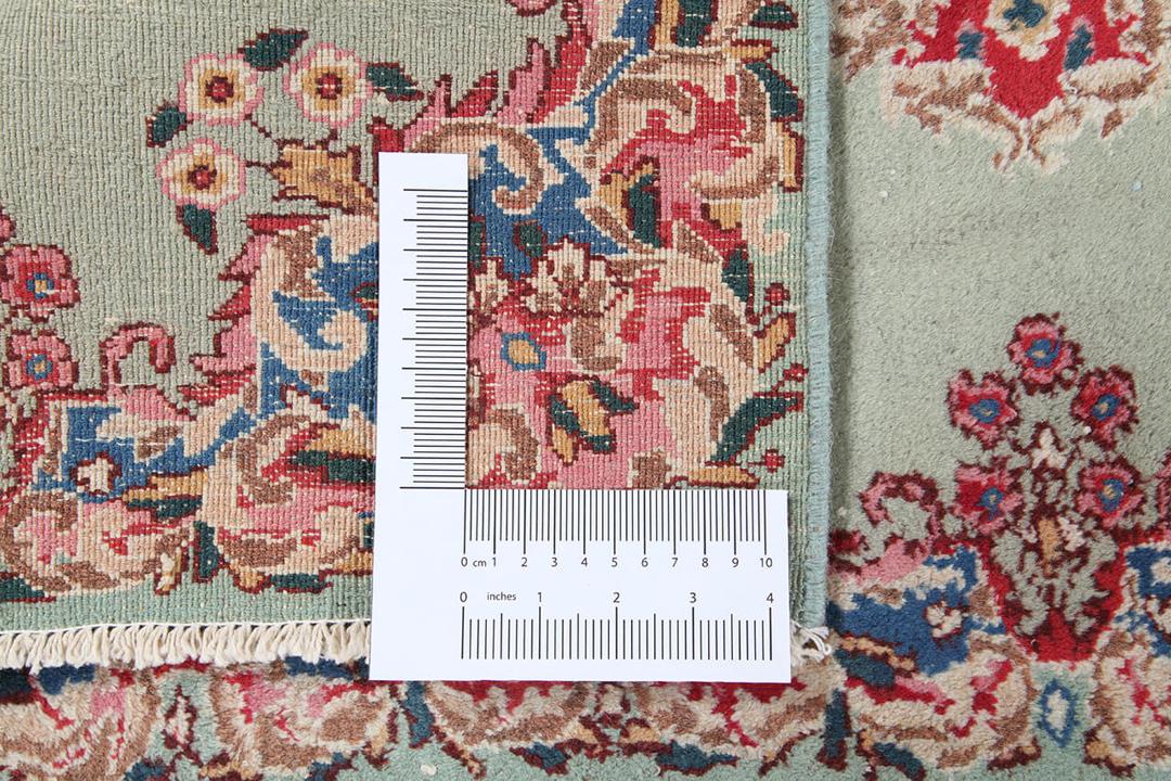 Antique Kerman rug from the Middle East in light-green with floral motifs