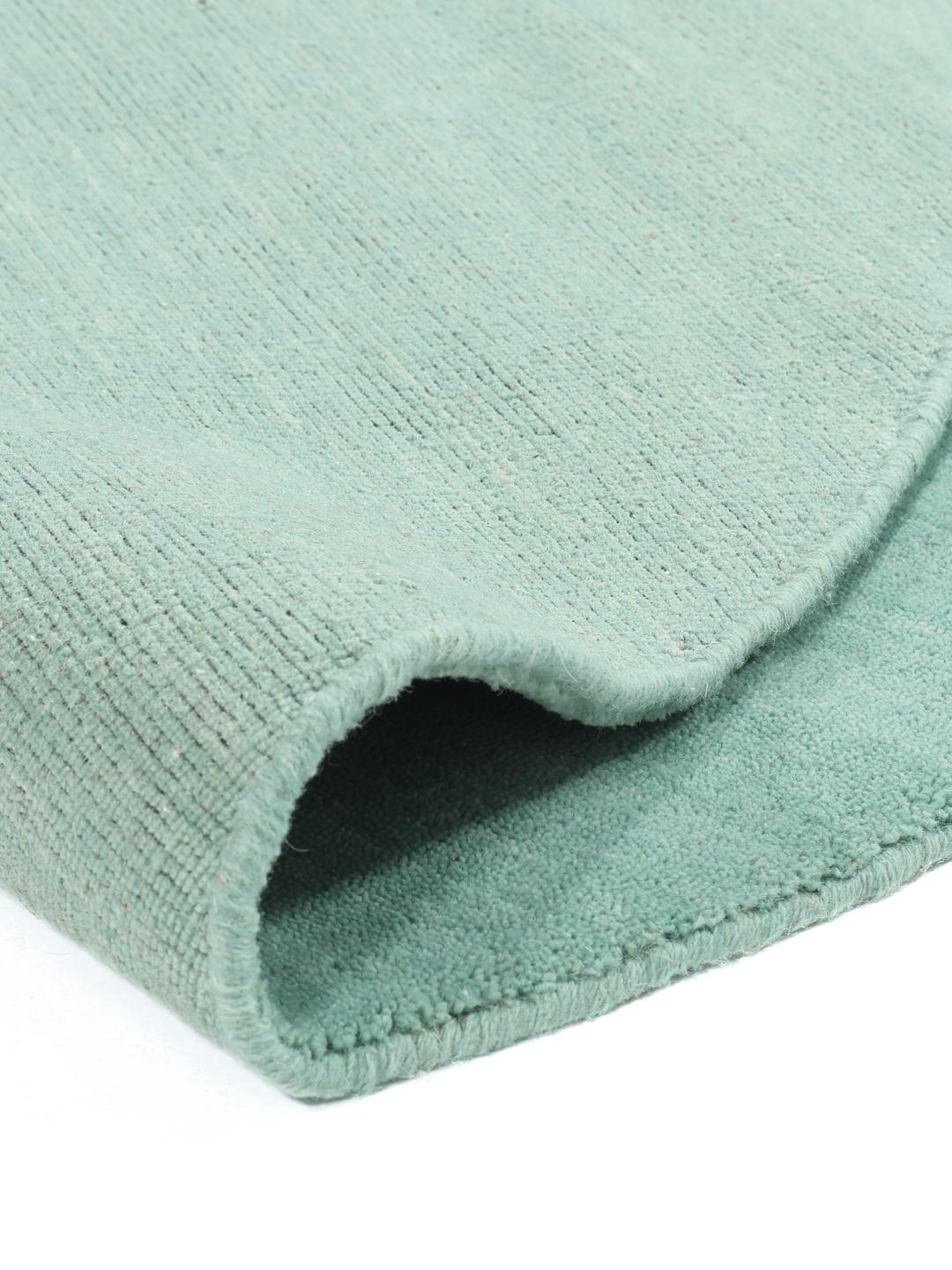 Round teal rug made from wool