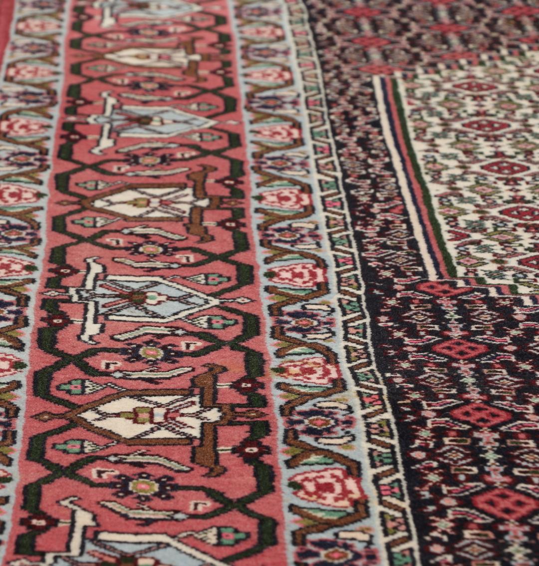 Een uniek handgeknoopt Senneh-tapijt uit het Midden-Oosten in donkerrood en beige.
