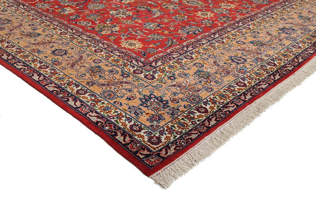 Een groot rechthoekig handgeknoopt Isfahan-tapijt uit het Midden-Oosten in rode en beigetinten.