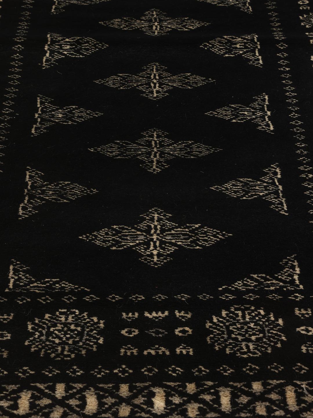 Hand-knotted Pakistan Bokhara runner with intricate motifs on a black background