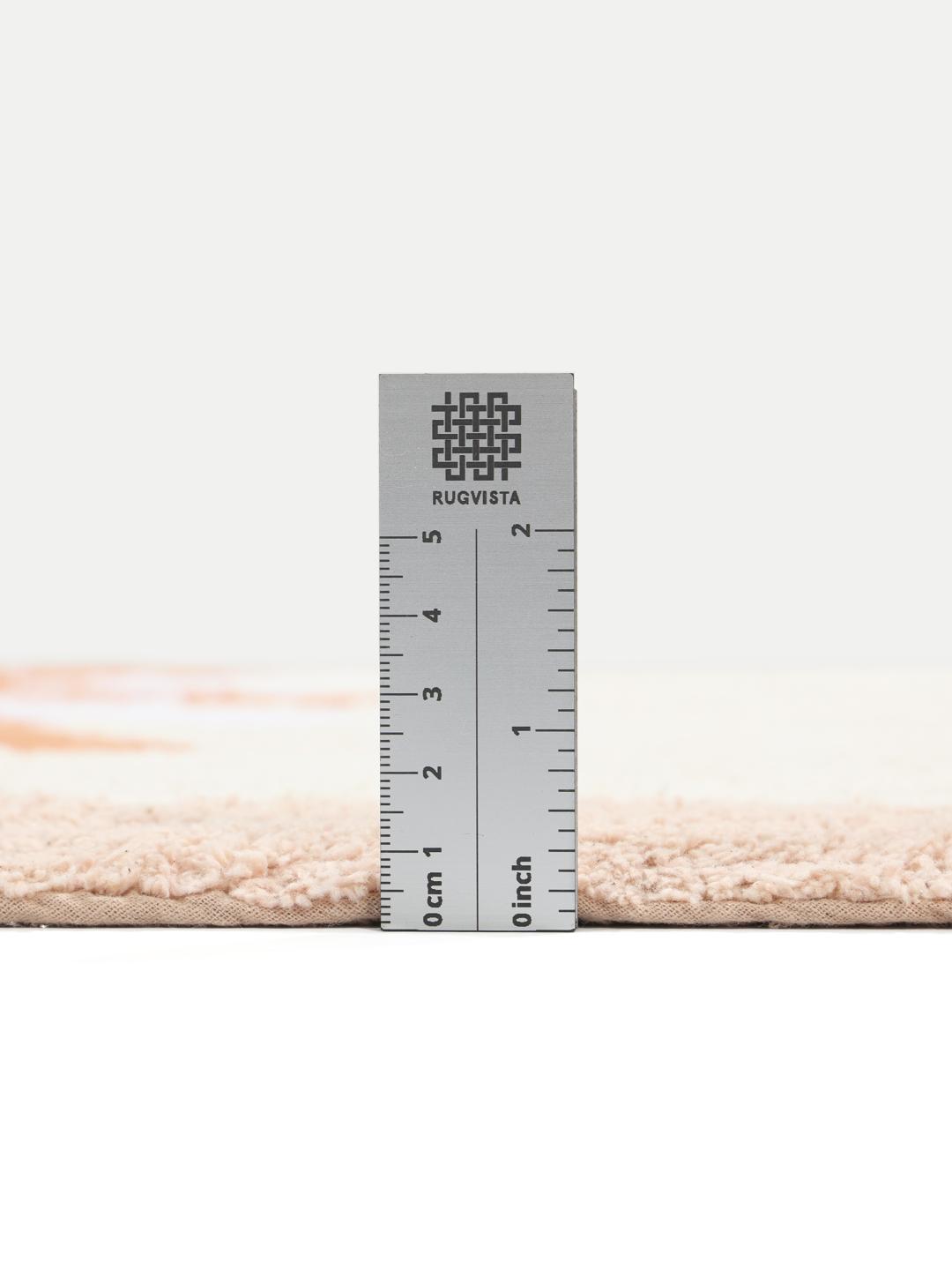 En rektangulær bademåtte med et solmotiv i terracotta, røde og lyserøde nuancer.