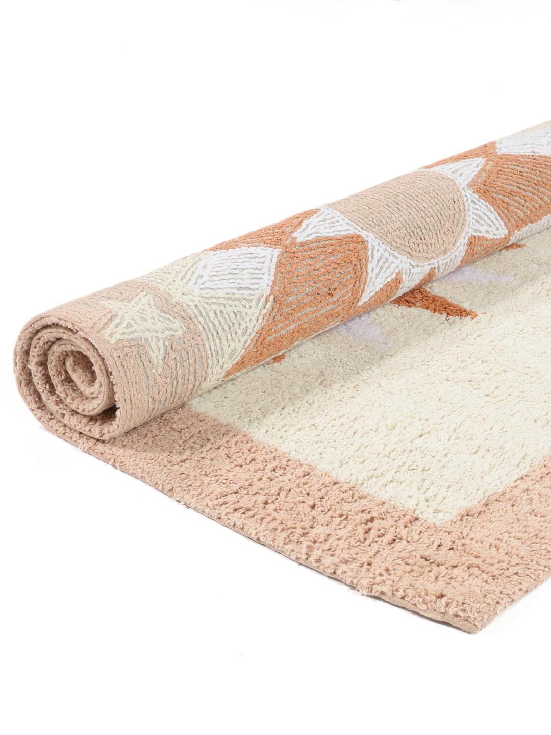 En rektangulær bademåtte med et solmotiv i terracotta, røde og lyserøde nuancer.