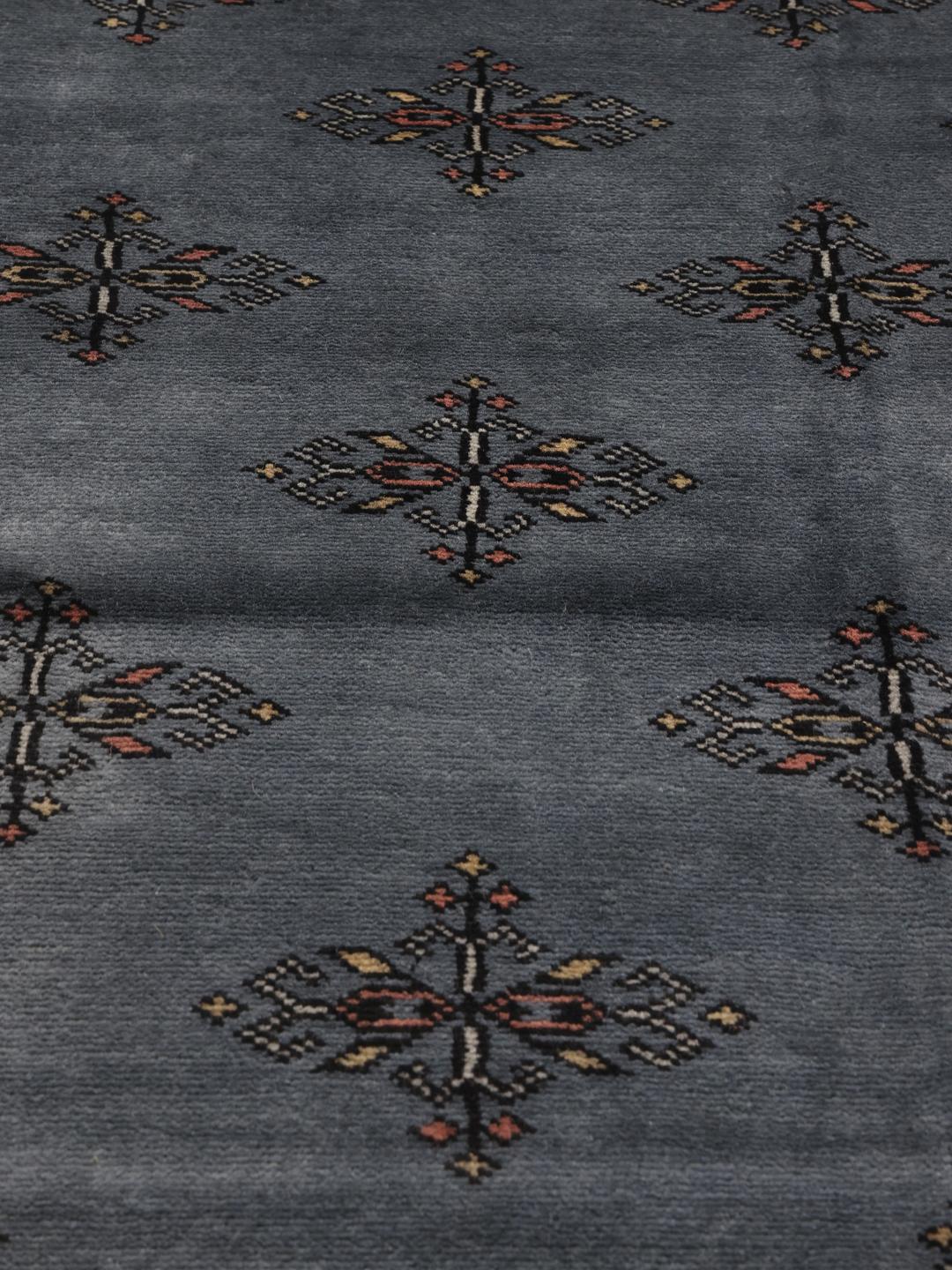 A hand-knotted Pakistan Bokhara 2ply rug with a blue field and repeating motifs.