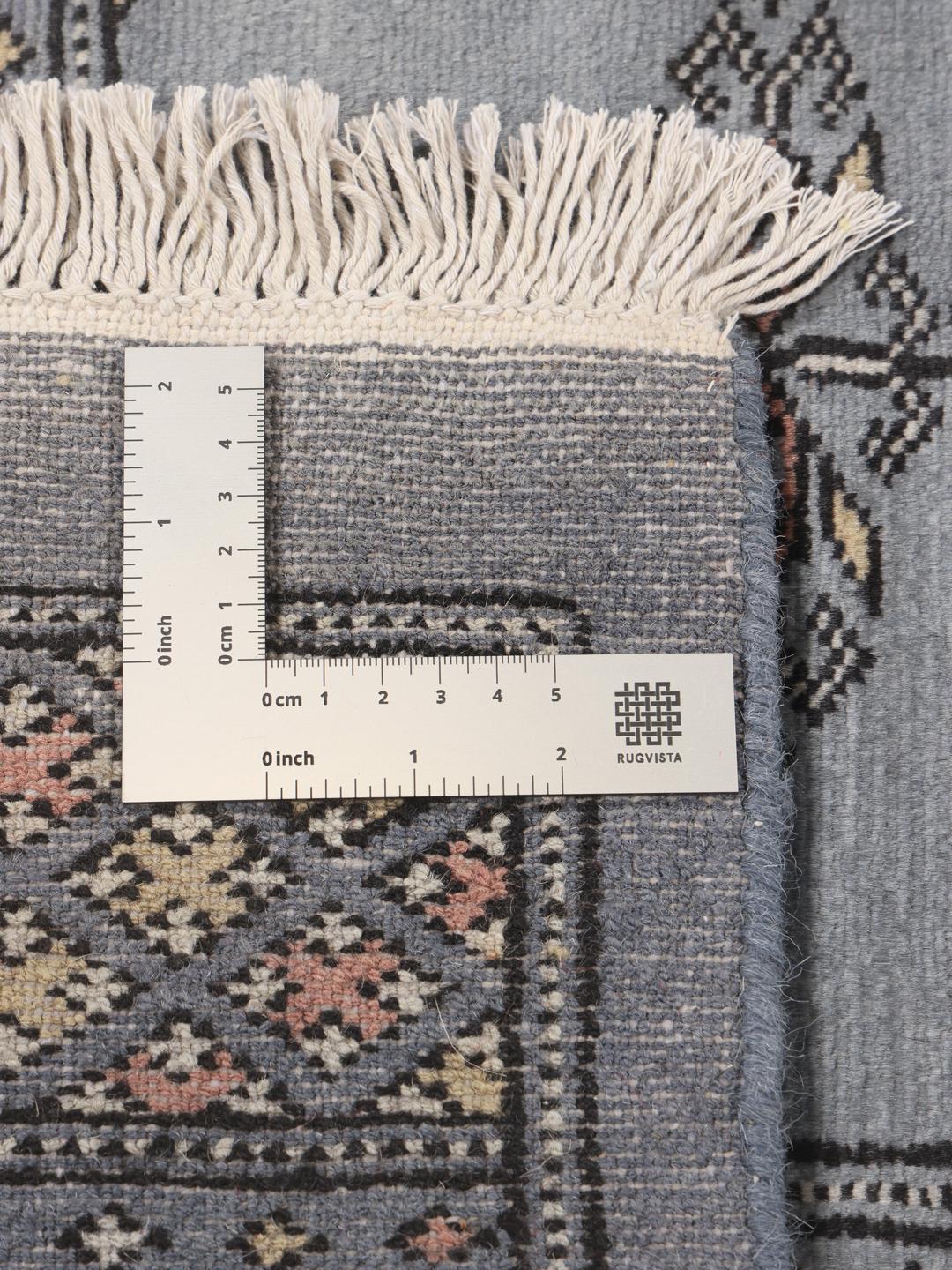 A hand-knotted Pakistan Bokhara 2ply rug with a blue field and repeating motifs.