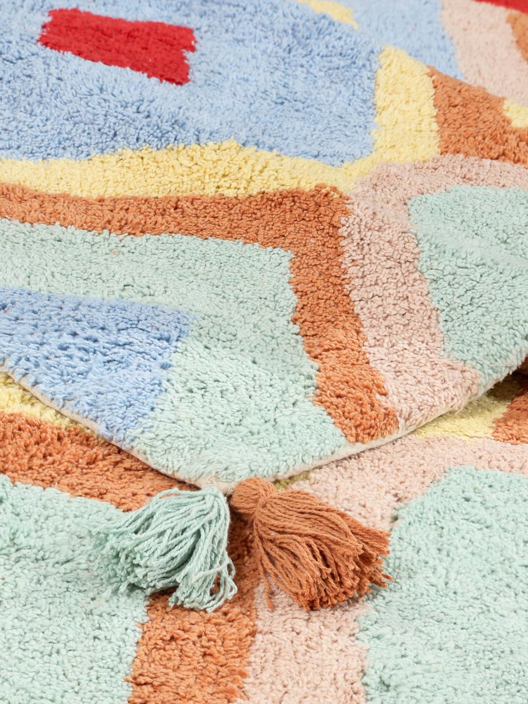 Een kleurrijke geometrische badmat met kwastjes aan de hoeken