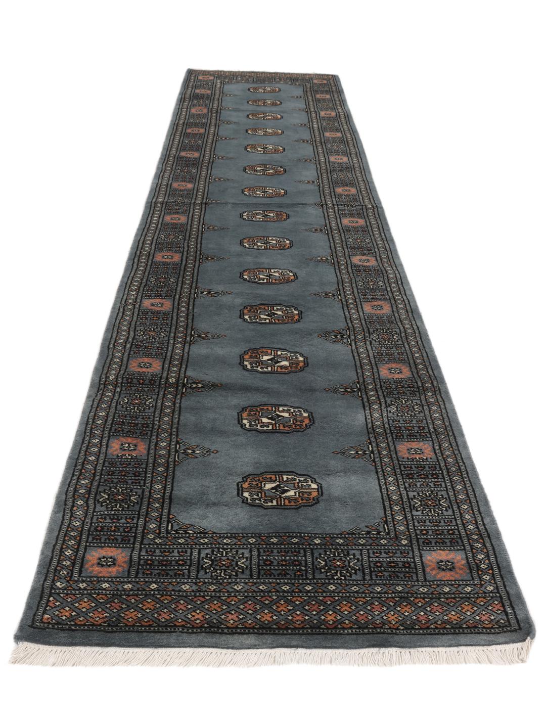 Hand-knotted blue runner from Pakistan featuring traditional repeating motifs