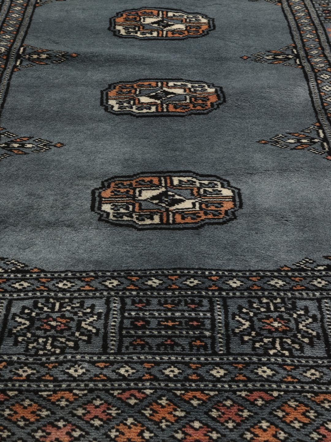 Hand-knotted blue runner from Pakistan featuring traditional repeating motifs